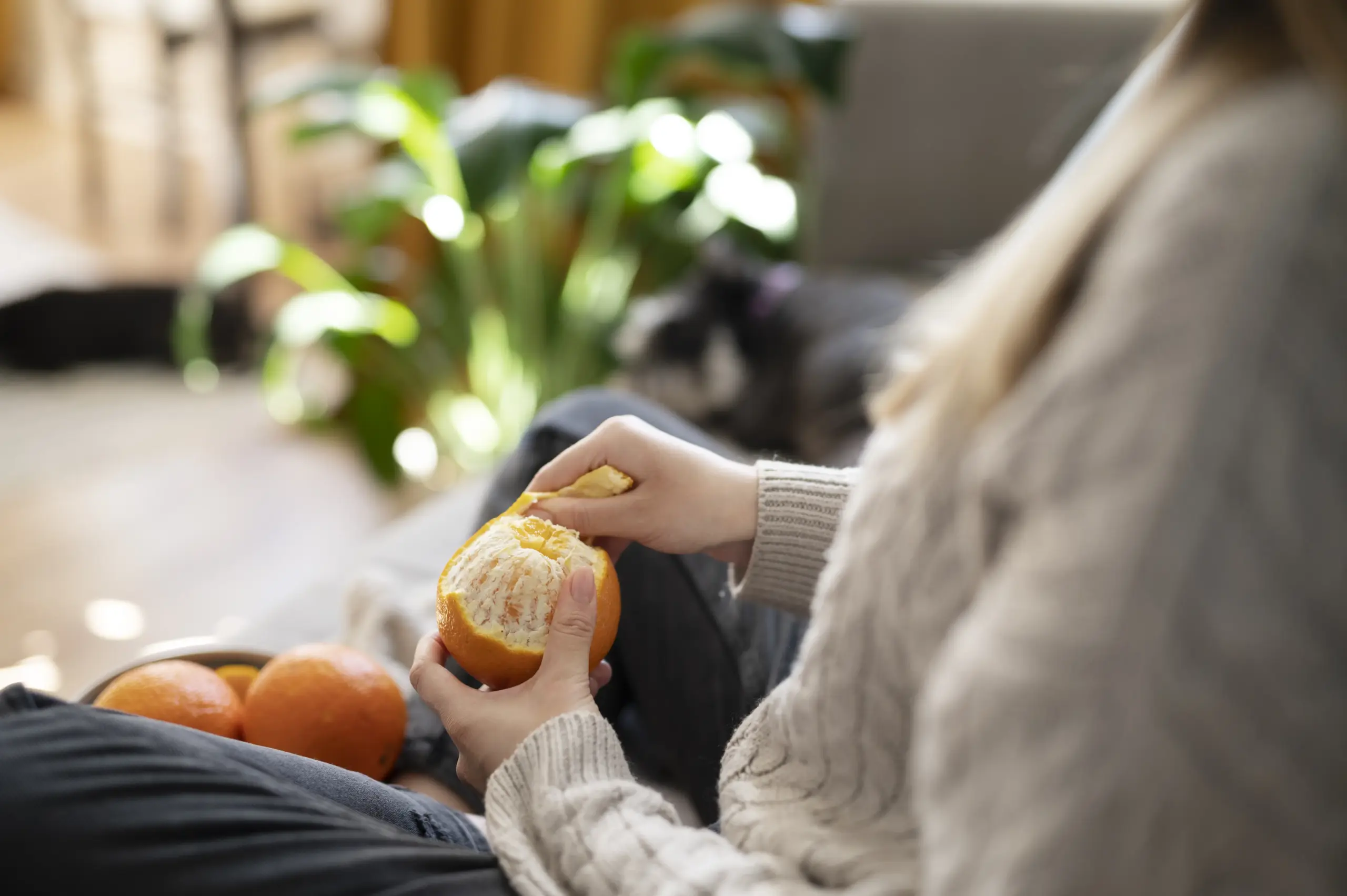 young woman peeling orange sofa scaled